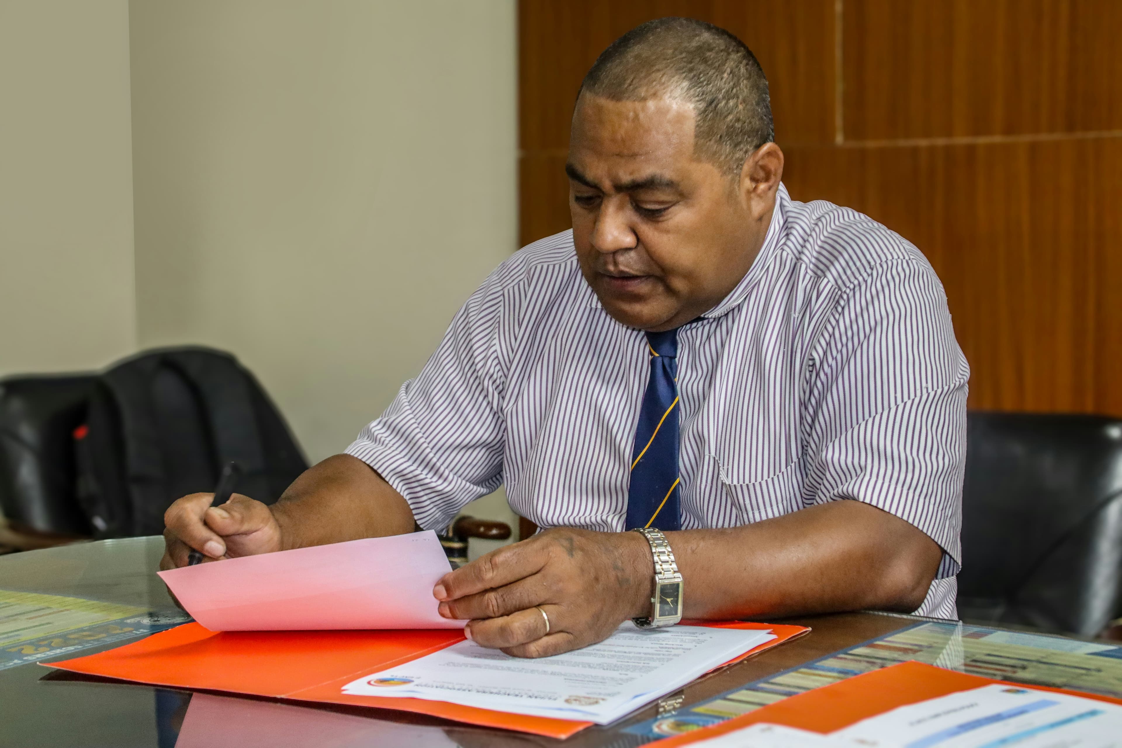 Directeur d'école signant des documents administratifs